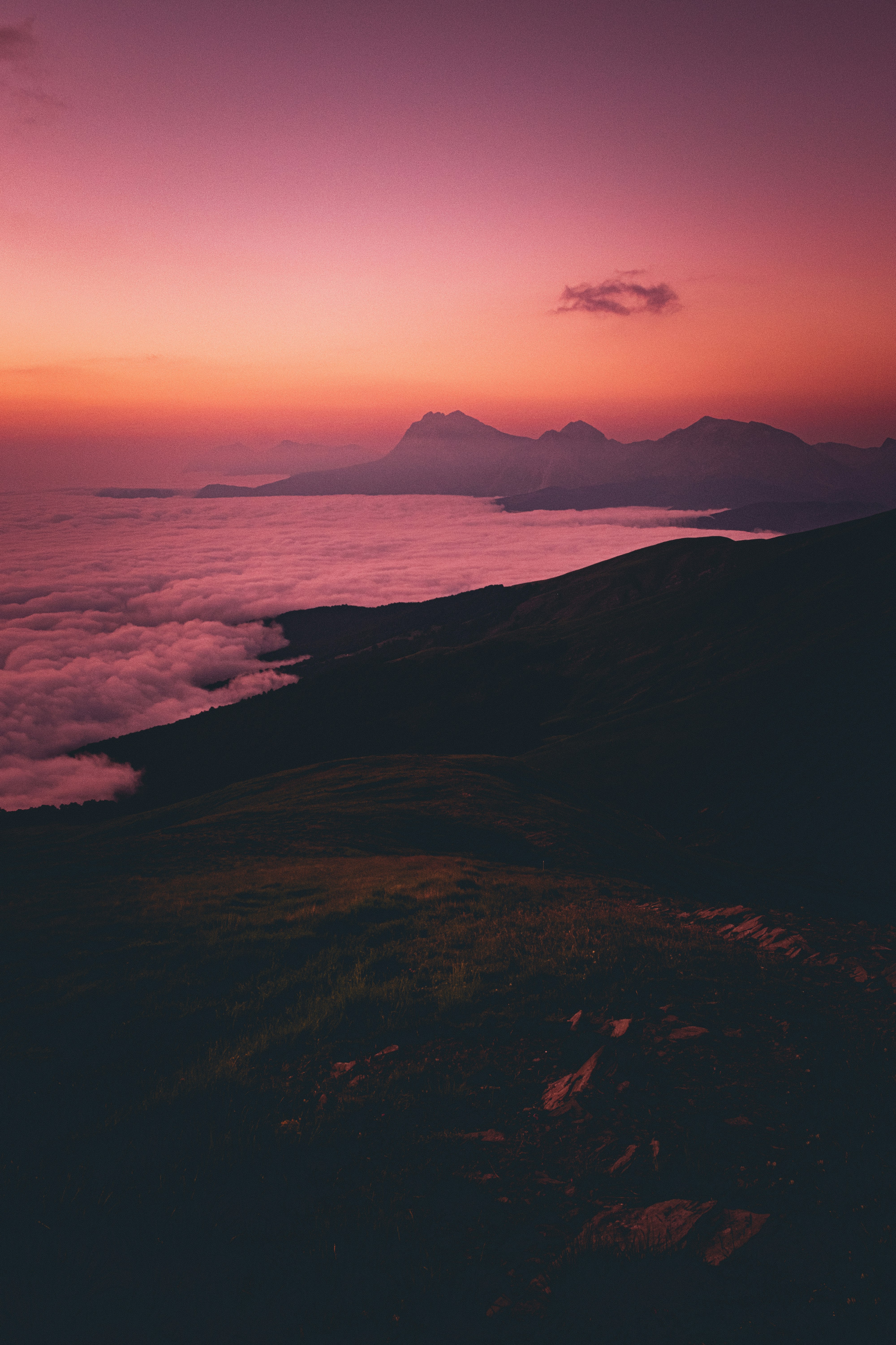 silhouette of mountains near body of water during sunset